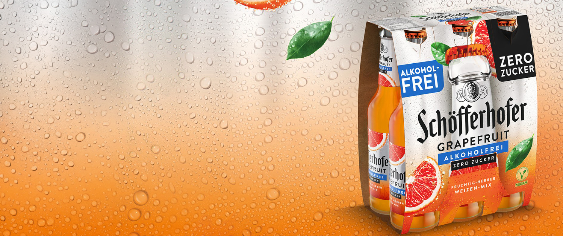 Ein Schöfferhofer Grapefruit Alkoholfrei Zero Sixpack vor betautem orange silbernem Hintergrund.
