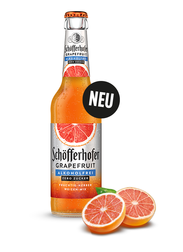 Eine Flasche Getränk mit der Aufschrift Grapefruit Alkoholfrei Zero Zucker steht neben zwei halbierten Grapefruits auf einem weißen Hintergrund.
