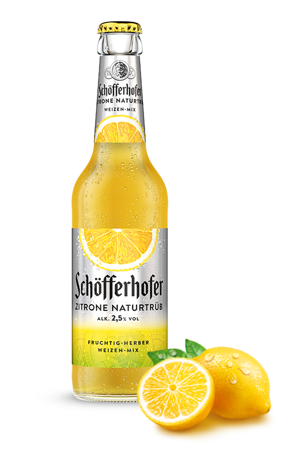 Eine Flasche Zitronenbier mit Kondensation steht neben einer aufgeschnittenen Zitrone.